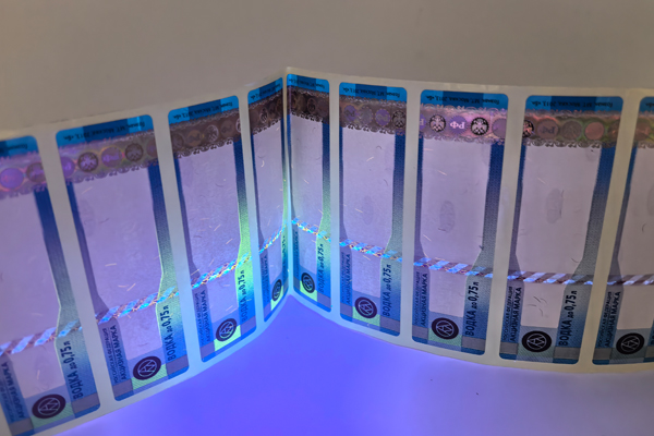 An inspector using a UV light to verify a tax stamp