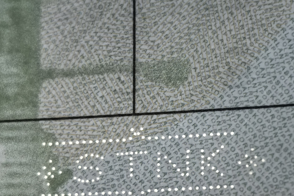 A magnifying glass over a document showing microtext