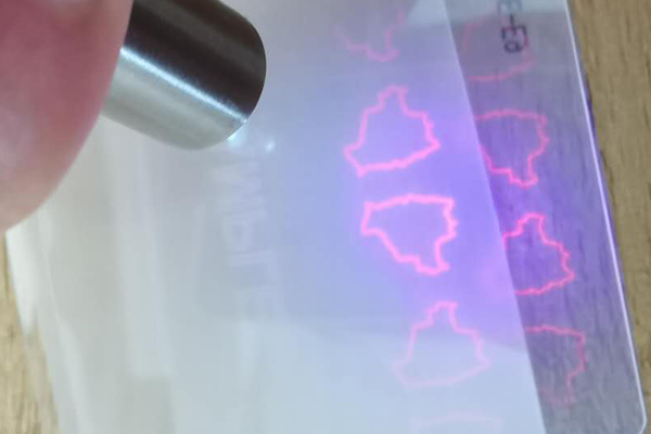 UV Invisible Security Ink A document under UV light showing invisible security printing.